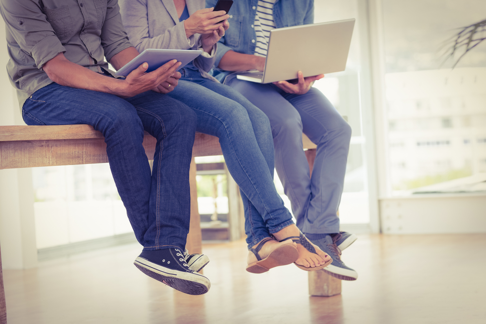 Three creative business team working on electronic devices in the office Three creative business team working on electronic devices in the office
